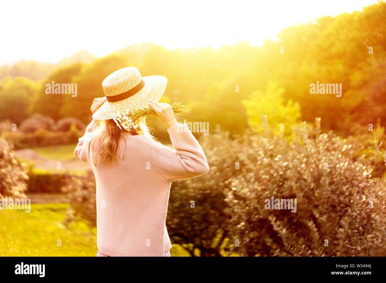 Ragazza nel cappello di paglia vista posteriore in Provenza e guardare il tramonto. Foto Stock