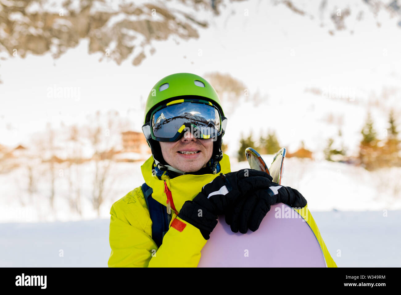 Immagine dell uomo sportive indossando il casco con lo snowboard sullo sfondo di montagne innevate Foto Stock