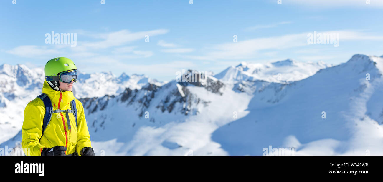 Immagine panoramica dell'uomo nel casco e con lo snowboard sullo sfondo del paesaggio innevato Foto Stock