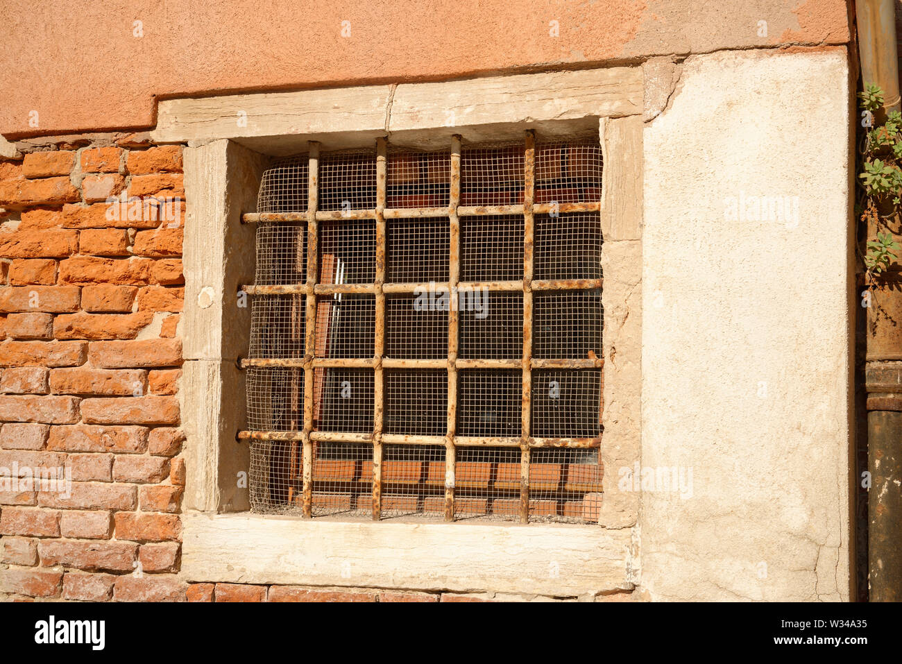 Base a forma di quadrato grill di metallo arrugginito come sicurezza per una finestra vetrata. Foto Stock