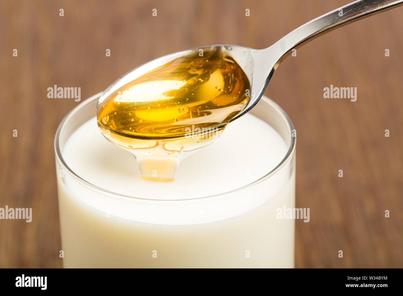 Il miele il latte isolate su sfondo marrone Foto Stock