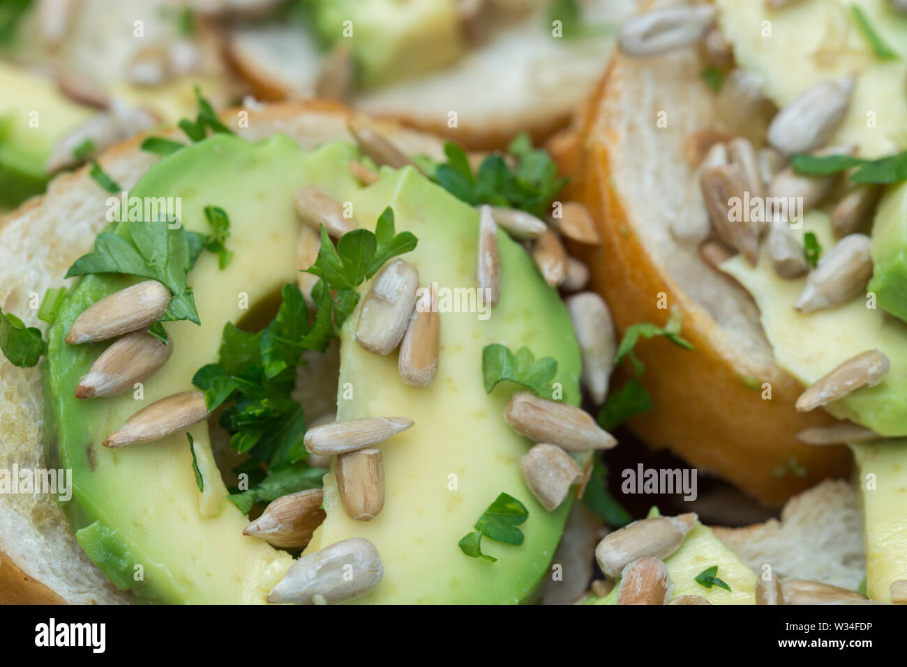 Vegan piccoli panini con avocado, prezzemolo e semi di girasole macro Foto Stock