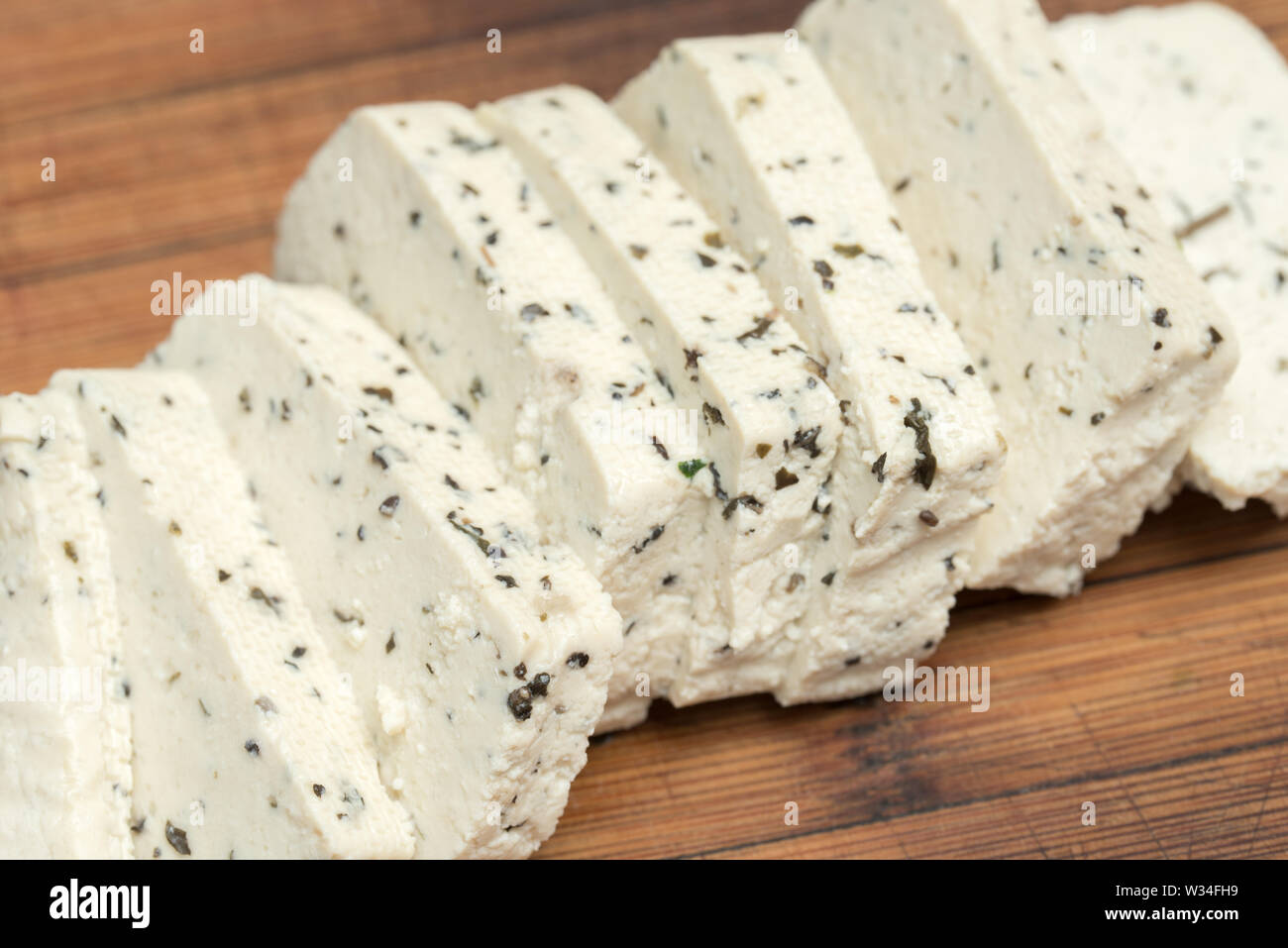 Il tofu con erbe fette sul bordo di taglio Foto Stock