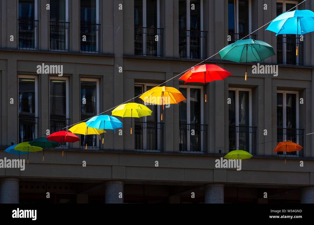 Ombrelloni colorati sospesi attraverso Walter Benjamin Platz a Berlino Foto Stock