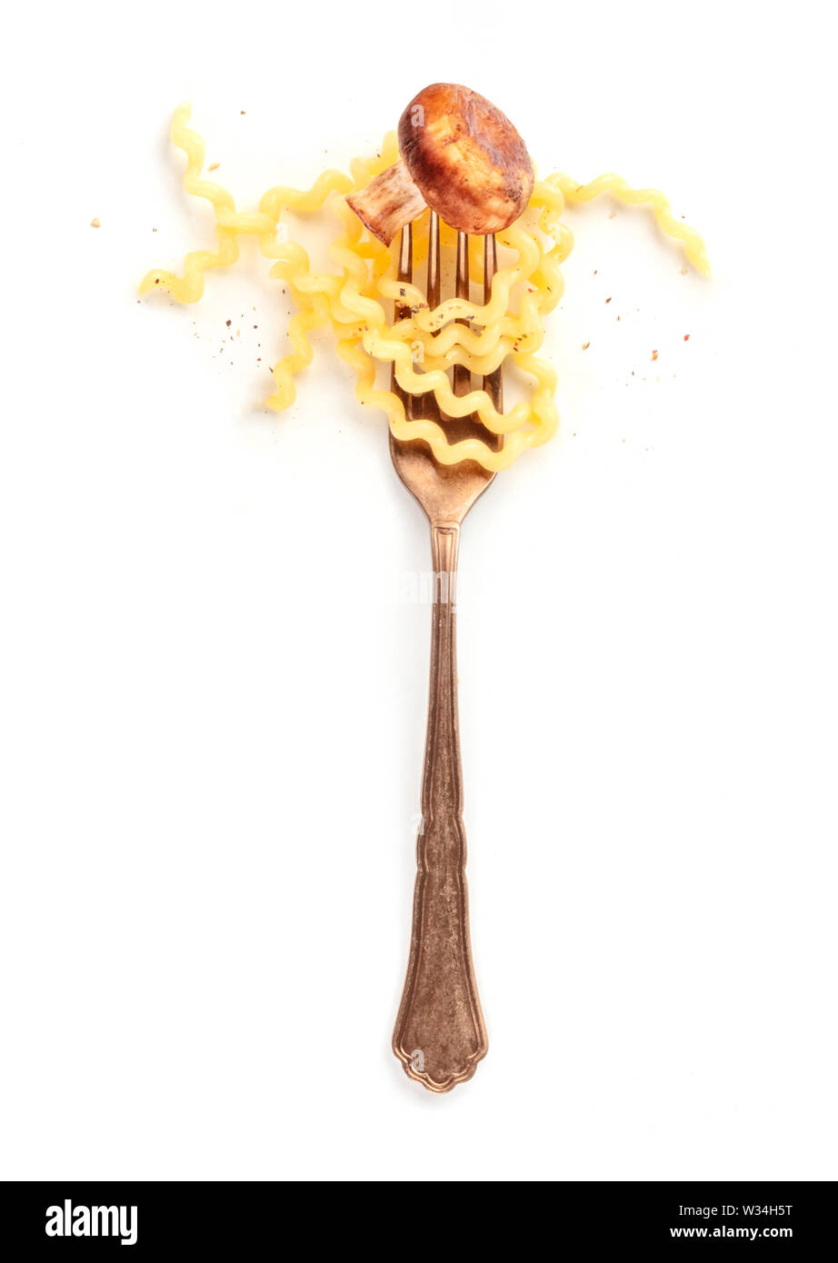 Pasta design. Una forcella con fusilli, un fungo fritto, e pepe, girato dalla parte superiore su uno sfondo bianco. Cucina Italiana concept Foto Stock