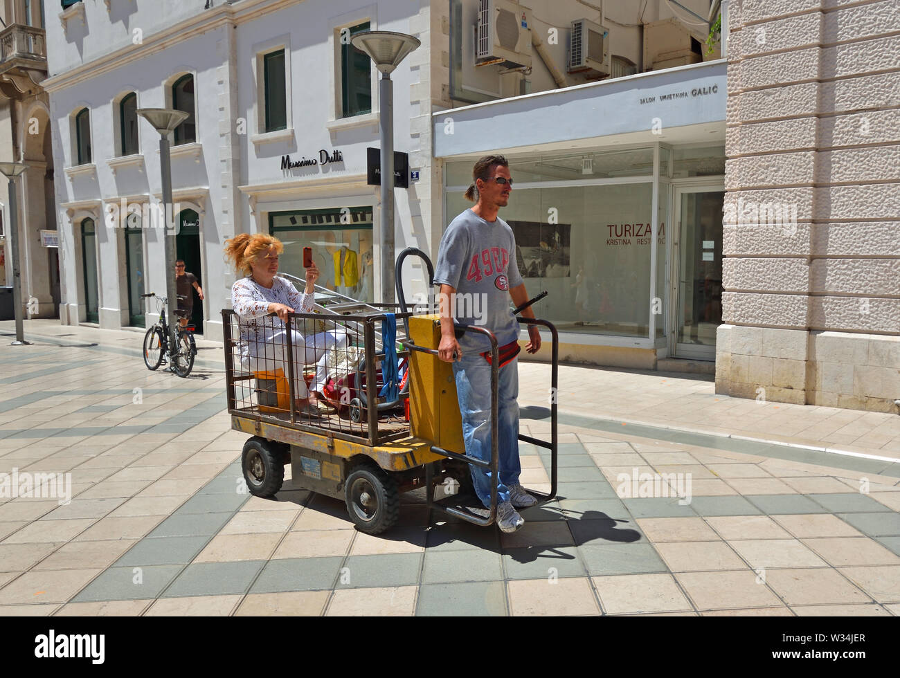 : Lady facendo un giro in un elettrico Carrello Bagagli, Split Croazia. Foto Stock