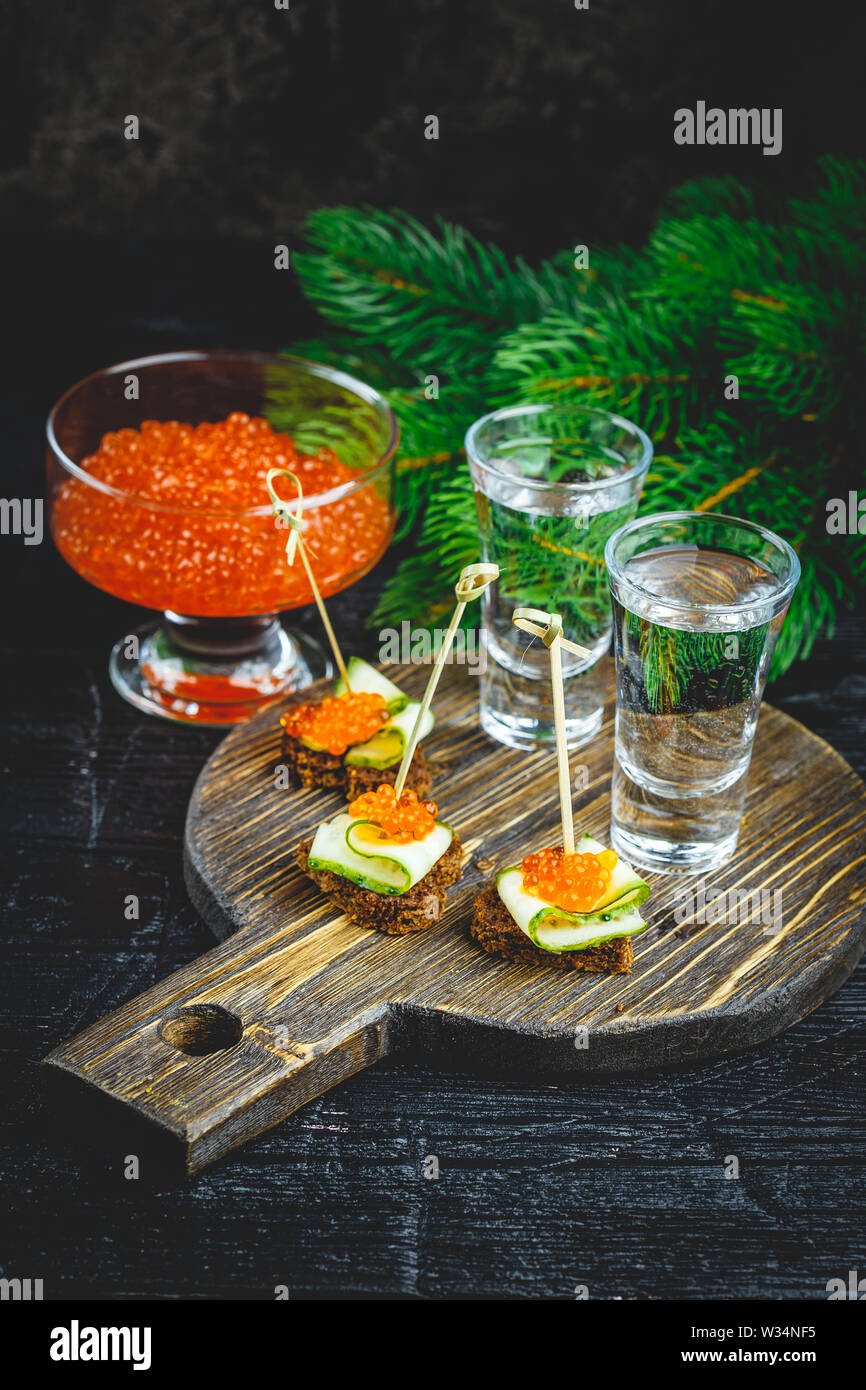 Deliziosi crostini con caviale rosso e due colpi di vodka. Foto Stock