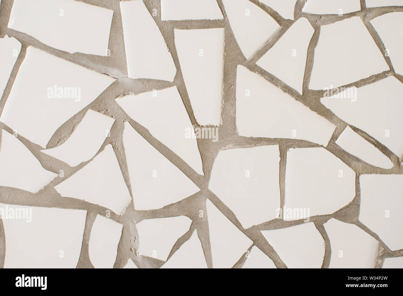 La superficie di molte piccole piastrelle bianche di diverse forme. Abstract mosaico di piastrelle in ceramica modellato sullo sfondo. Ottimo per la progettazione e lo sfondo di texture Foto Stock
