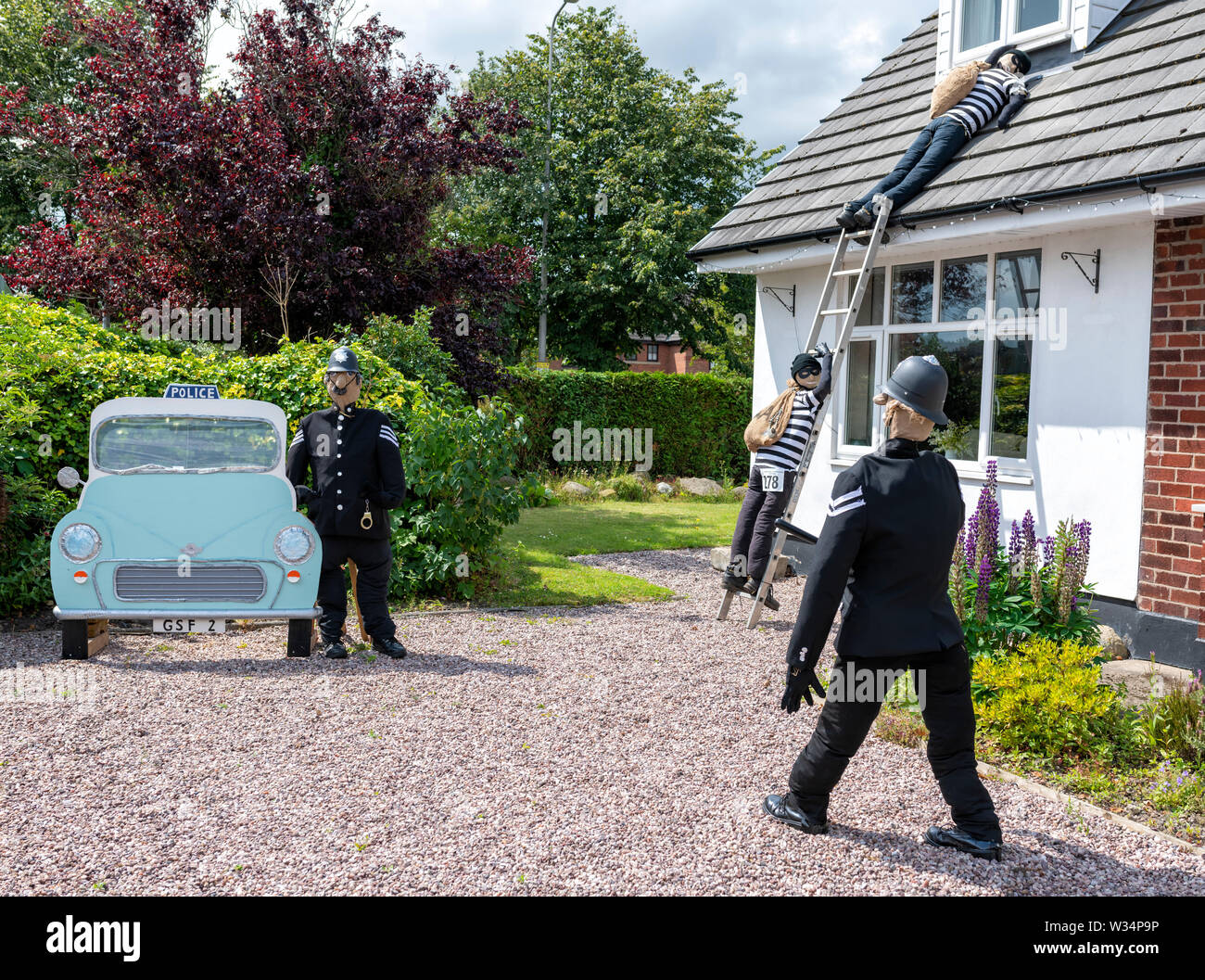 Una mostra a Garstang Spaventapasseri Festival. Gli ufficiali di polizia cattura i ladri di rottura in una casa Foto Stock