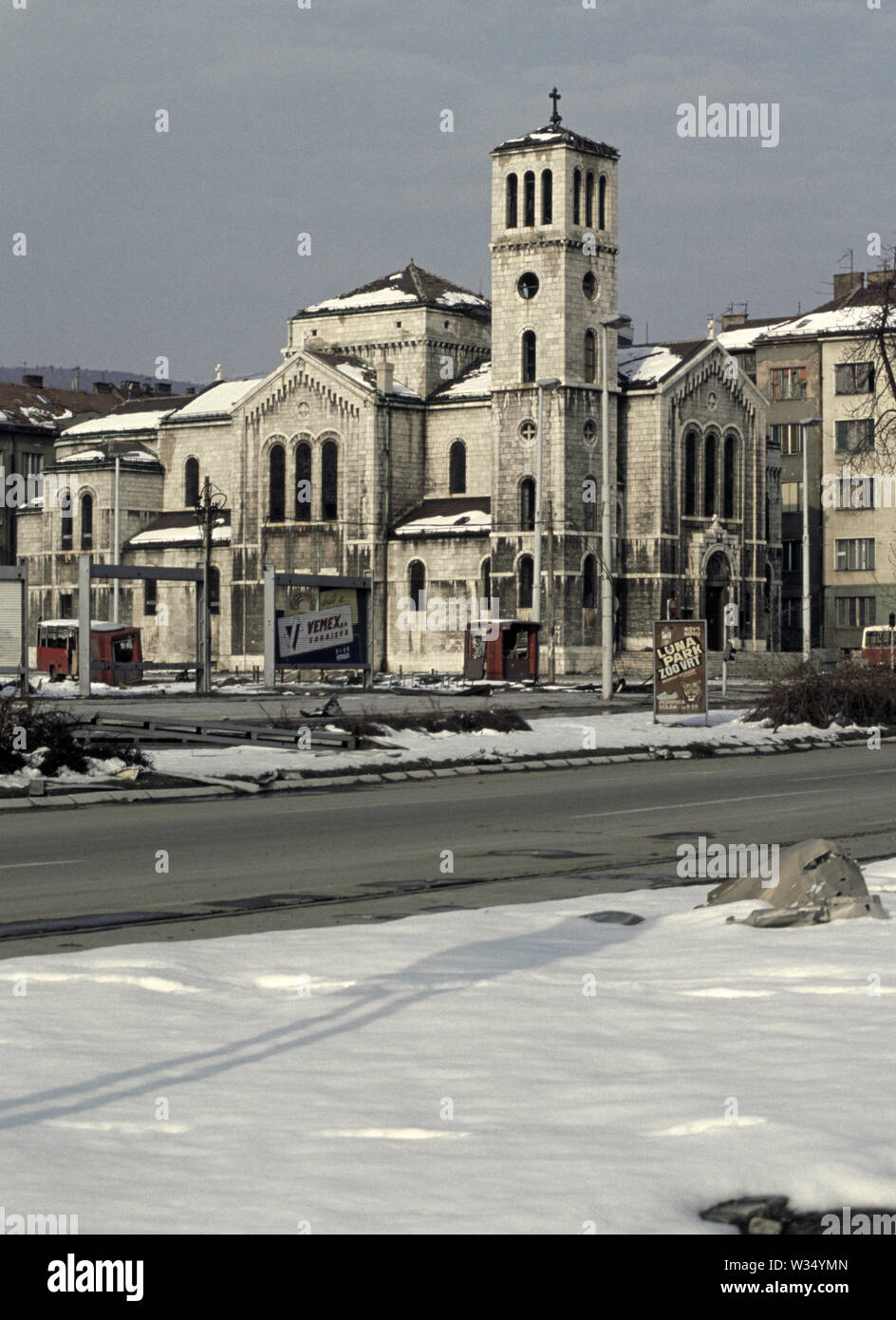 2 aprile 1993 durante l'assedio di Sarajevo: San Giuseppe (Chiesa Cattolica Romana) attraverso "Vicolo niper' (Zmaja od Bosne), visto dalla parte anteriore del complesso edificio. Foto Stock