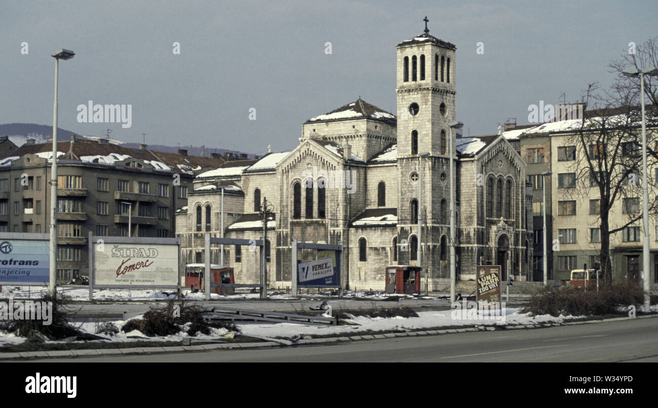 2 aprile 1993 durante l'assedio di Sarajevo: San Giuseppe (Chiesa Cattolica Romana) attraverso "Vicolo niper' (Zmaja od Bosne), visto dalla parte anteriore del complesso edificio. Foto Stock