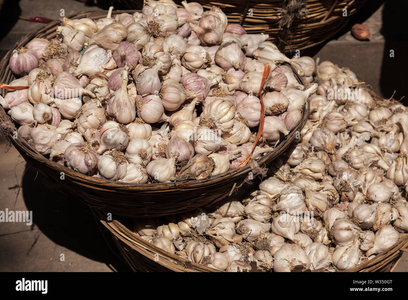 Cestini di aglio per la vendita su un mercato di strada a Kathmandu Foto Stock