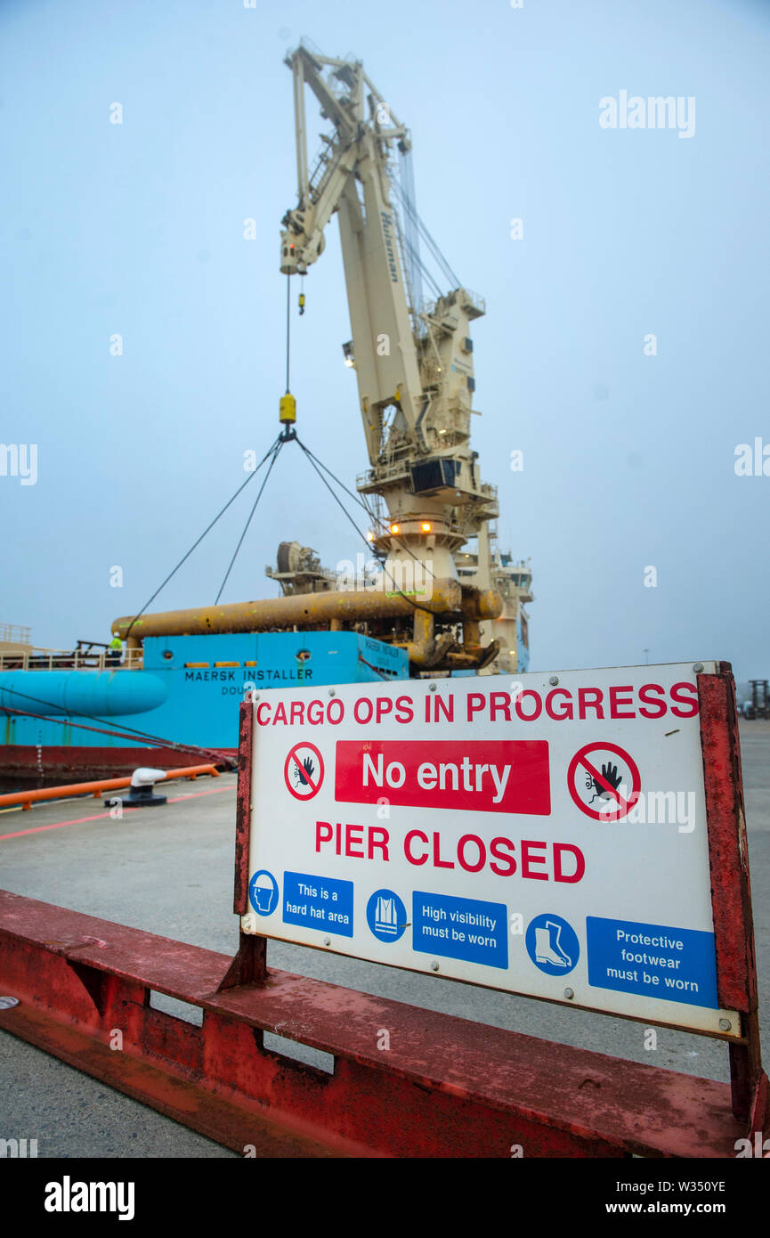 Maersk Installer di attraccare in Lerwick Shetland lo scarico dalla gru smantellata una parte di una piattaforma petrolifera sulla banchina del petrolio del Mare del Nord i campi Foto Stock