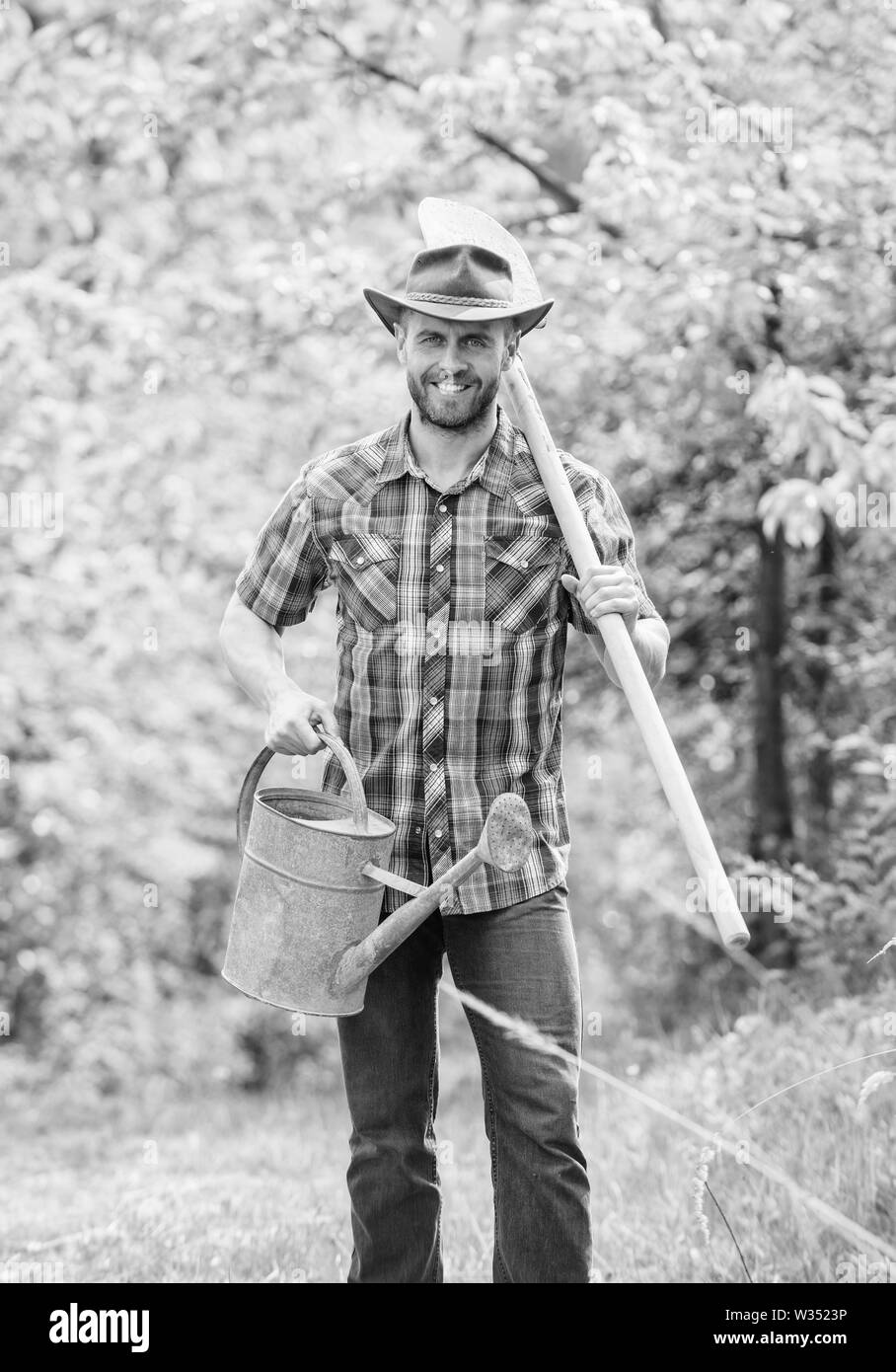 La coltivazione di piante. Coppia guy cappello da cowboy con annaffiatoio e pala. Arbor Day. La piantagione di alberi. Impegno e responsabilità. Concetto di agricoltura. La semina in giardino. La piantumazione di alberi di tradizione. Foto Stock