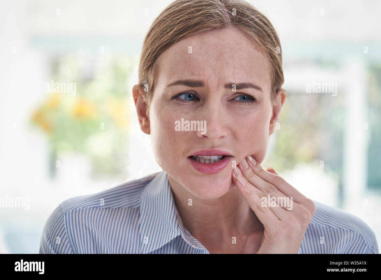 La donna soffre di mal di denti tocchino la ganascia Foto Stock
