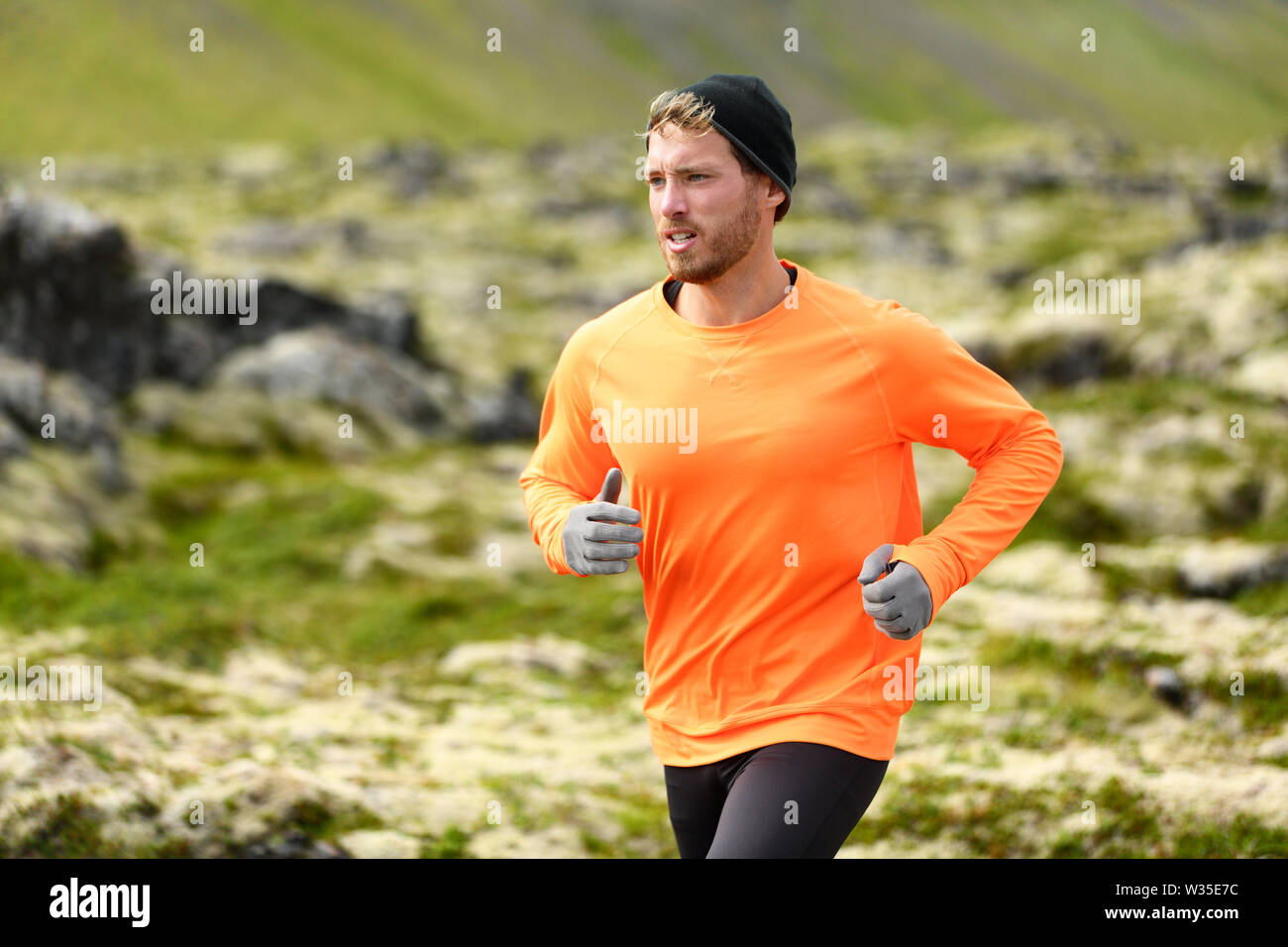 Runner. Sport con uomo che corre nel cross country trail run. Atleta maschio esercizio e formazione all'aperto nella splendida natura della montagna paesaggio. Foto Stock