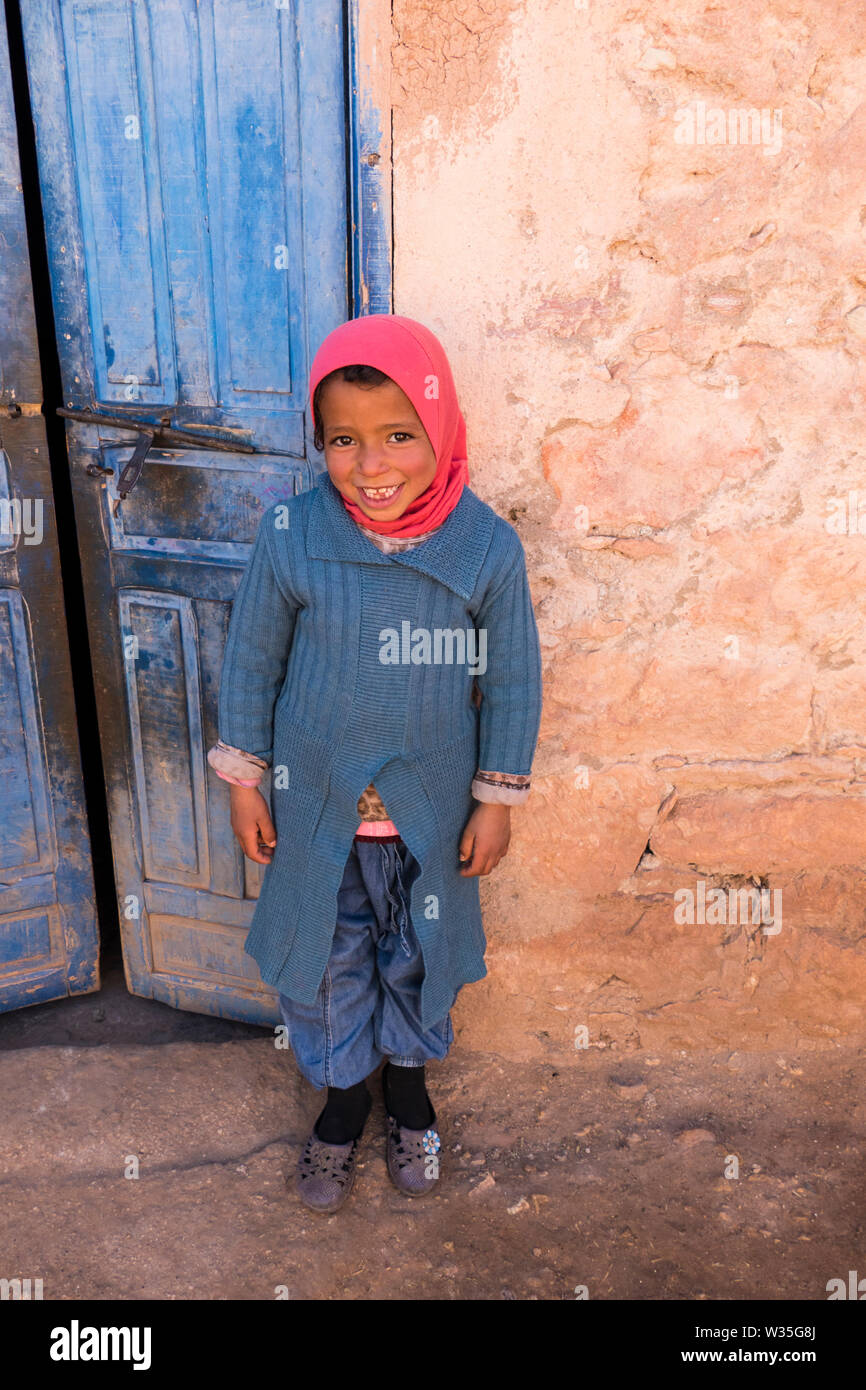 Un tradizionale piccolo felice ragazza berbera in una casa berbera in un villaggio vicino a Marrakresh in Marocco in Nord Africa sorridente alla fotocamera. Foto Stock