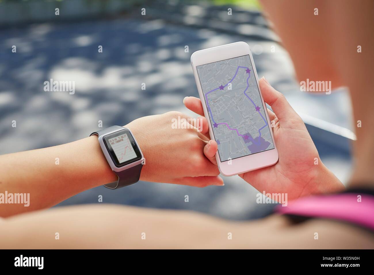 Donna che indossa orologio sportivo e tenendo lo smartphone. Foto Stock