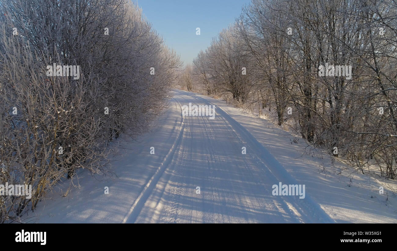 Vista aerea del paesaggio invernale con il trasporto su strada e gli alberi coperti di neve. Inverno in campagna Foto Stock