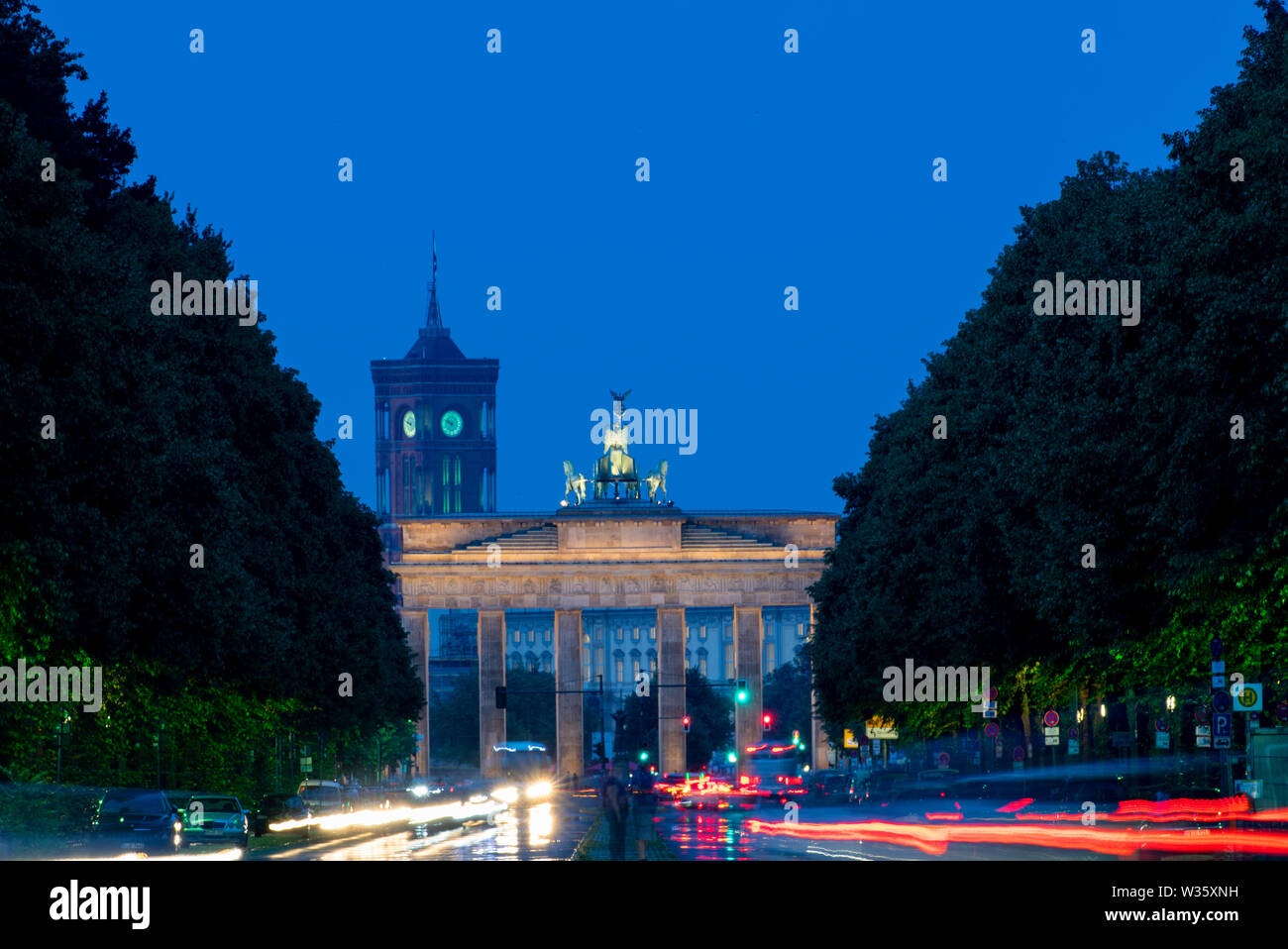 Berlino, Germania. 12 Luglio, 2019. Il passaggio di auto lascia tracce di luce sulla Strasse des 17. Juni. Sullo sfondo è possibile vedere la Porta di Brandeburgo e la torre della città rossa Hall (foto con esposizione a lungo termine). Credito: Monika Skolimowska/dpa-Zentralbild/dpa/Alamy Live News Foto Stock