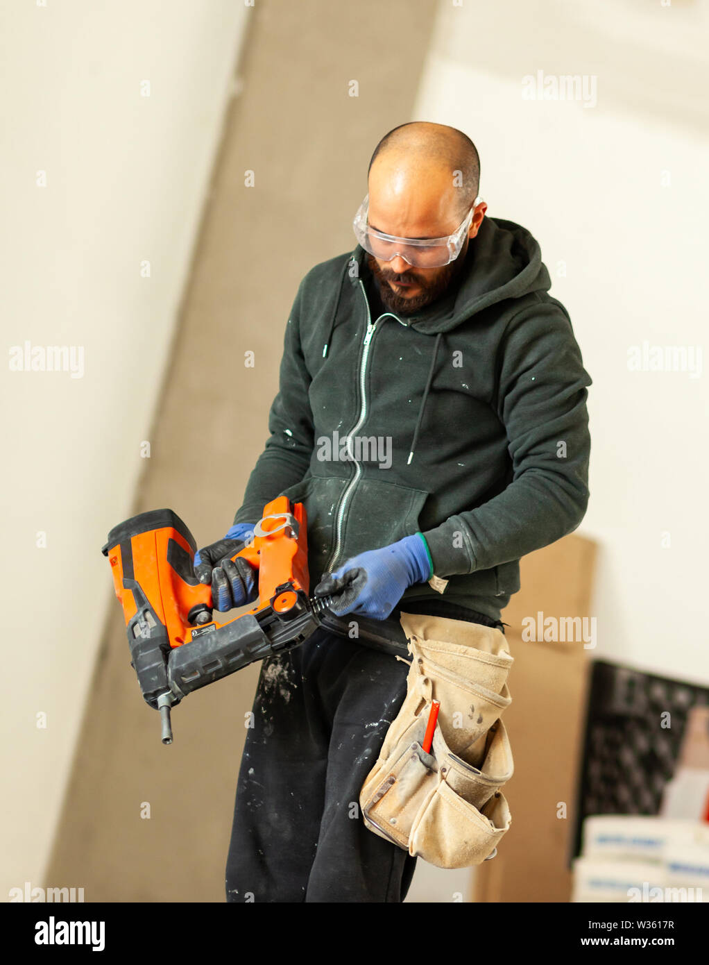 Lavoratore a lavorare per la costruzione di una parete di cartongesso. Foto Stock