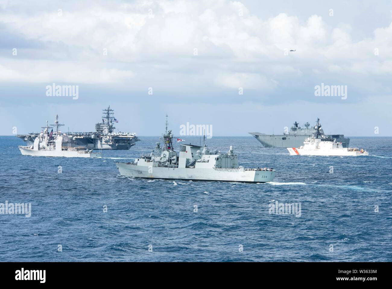 190711-N-DX072-1052 Mare di Tasman (Luglio 11, 2019), Stati Uniti Nimitz Navy-class portaerei USS Ronald Reagan (CVN 76), in alto a sinistra, IL GOVERNO DEGLI STATI UNITI Navy Ticonderoga-class guidato-missili cruiser USS Chancellorsville (CG 62), sinistra, il Royal Canadian Navy Halifax-classe fregata HMCS Regina (FFH 334), al centro, il Royal Marina australiana Canberra-class atterraggio elicottero nave dock HMAS Canberra (L02), in alto a destra e la legenda di classe USCGC taglierina Stratton (WMSL 752), a destra il transito dal trasporto anfibio dock nave USS Green Bay (LPD) 20 in una foto esercizio (PHOTOEX) durante il talismano Sabre 2019. Green Bay, p Foto Stock