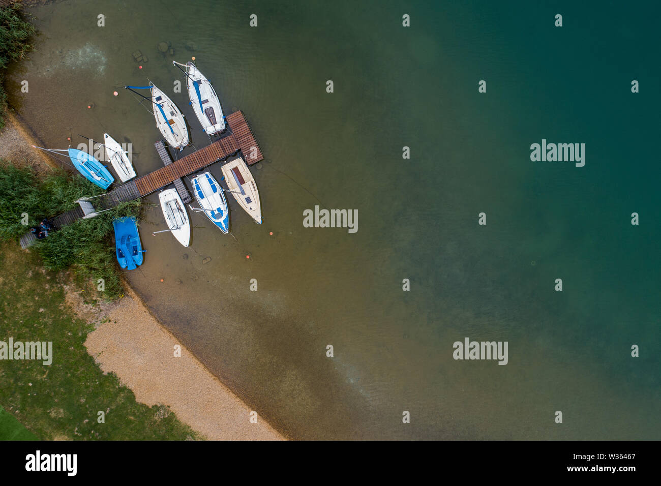 Borken, Germania. 11 Luglio, 2019. Barche di sport a giacere su un molo nel lago Singlis. Per 4.5 milioni di euro, il sito con il famoso lago Freizeitsee è in vendita in Nord Hesse (fotografia aerea con un drone). Credito: Swen Pförtner/dpa/Alamy Live News Foto Stock