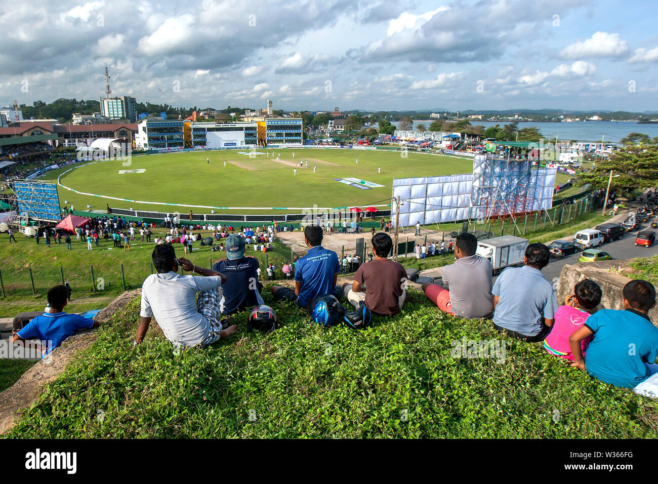 Spettatori godere della vista di una partita di cricket dalla parte superiore della Vecchia Fortezza Olandese di Galle nel sud dello Sri Lanka. Foto Stock