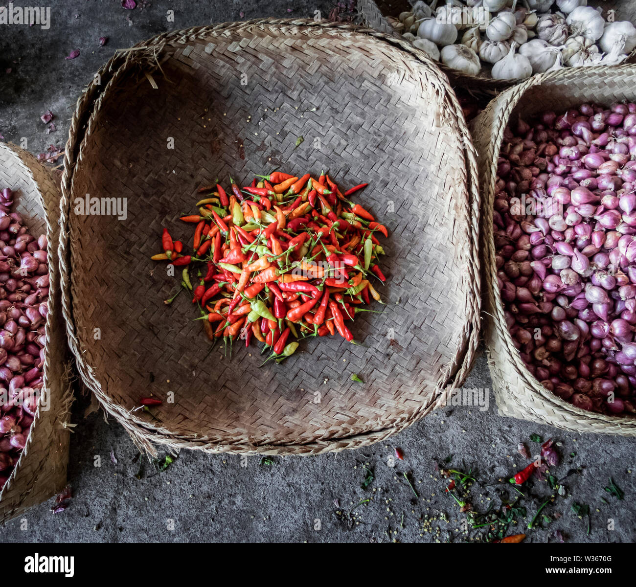 Peperoncino piccante fresco in un tradizionale cestello asiatici fatte di foglie di palma Foto Stock