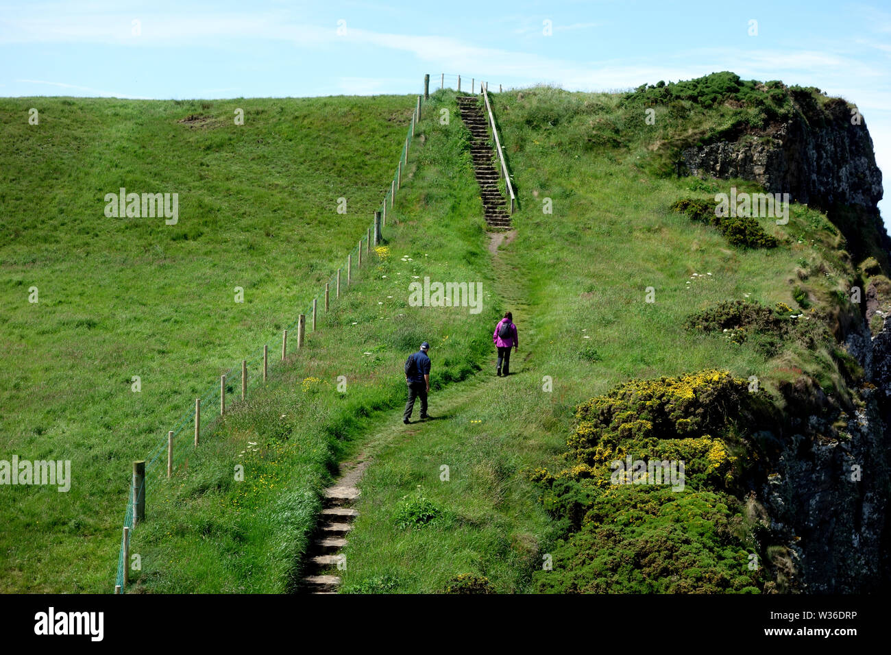 Un paio di piedi passi sulla Giant's Causeway sentiero costiero, County Antrim, Irlanda del Nord, Regno Unito Foto Stock