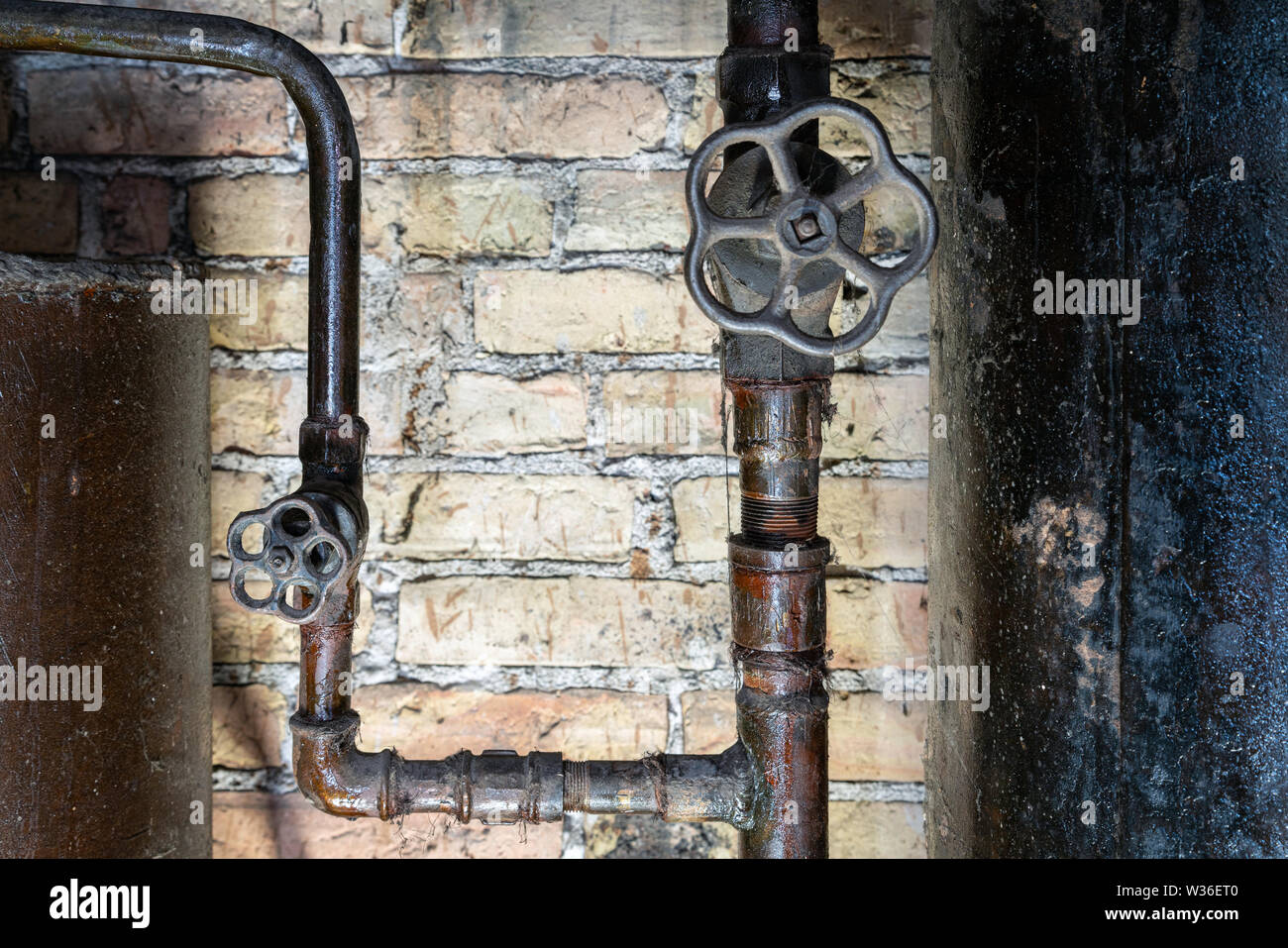 Rusty valvole sul locale caldaia tubi. Metallo vecchia caldaia di riscaldamento di generazione e di consegnarla a casa tramite pipeline Foto Stock