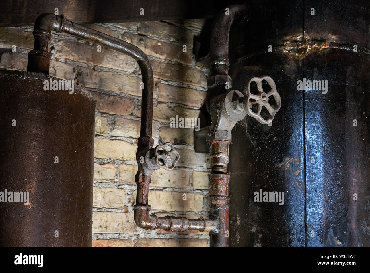 Rusty sala caldaia tubi. Metallo vecchia caldaia di riscaldamento di generazione e di consegnarla a casa tramite pipeline. Acqua calda o gas viene fornito con questo Foto Stock