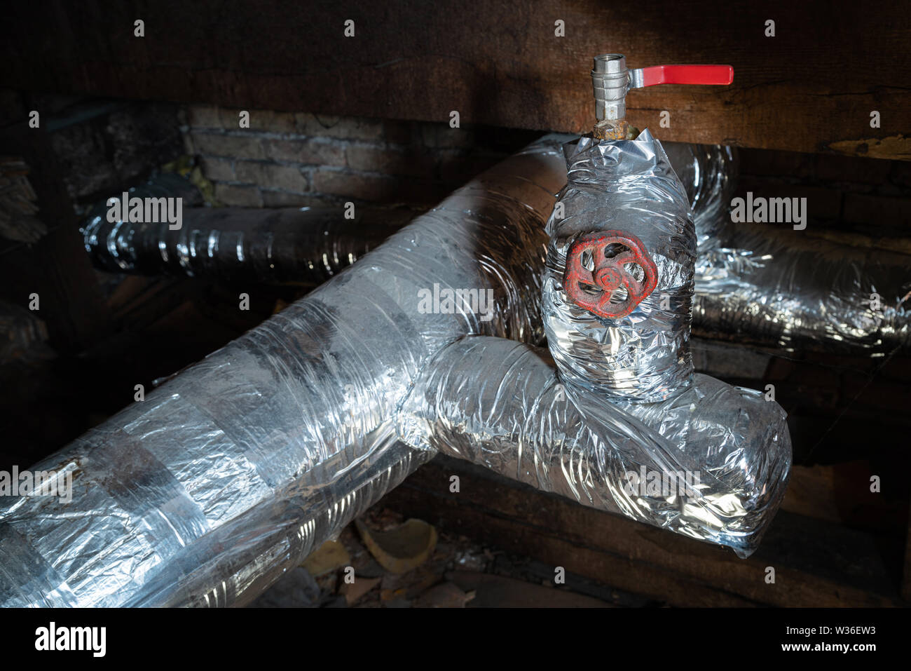 Argento vecchio centro di tubi di riscaldamento in camera oscura per interni. Metallo vecchia caldaia di riscaldamento di generazione e di consegnarla a casa tramite pipeline Foto Stock