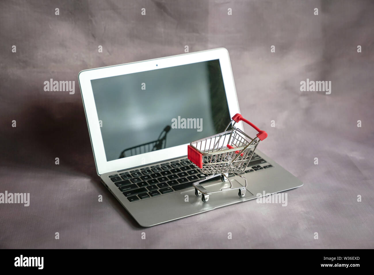 Mini carrello su un laptop. Shopping online o il concetto di ecommerce. Foto Stock