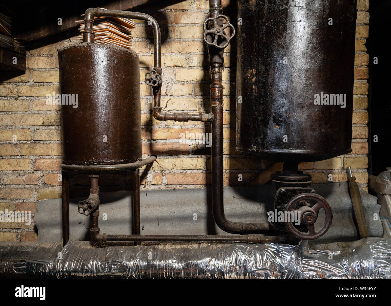 Rusty sala caldaia tubi. Metallo vecchia caldaia di riscaldamento di generazione e di consegnarla a casa tramite pipeline. Acqua calda o gas viene fornito con questo Foto Stock