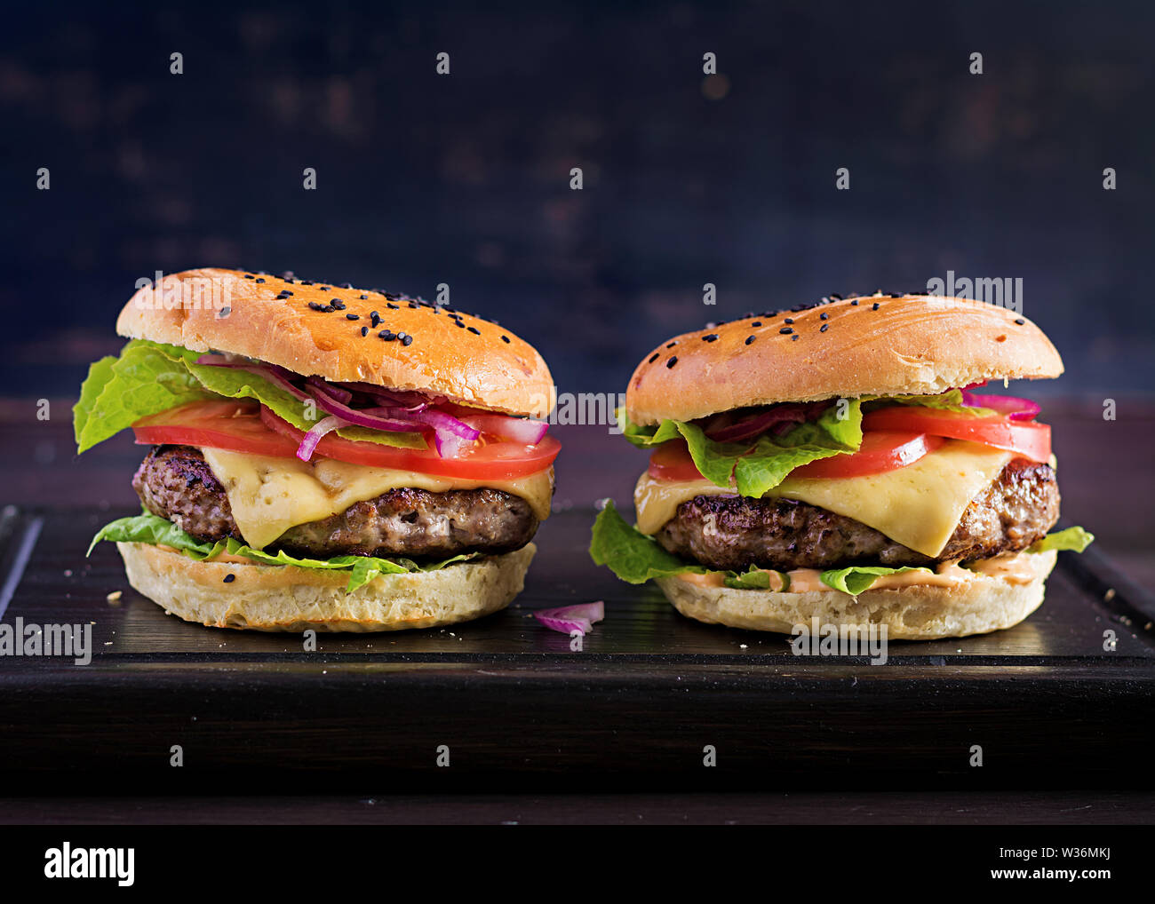 Grande panino - hamburger burger con carne di manzo, pomodoro, formaggio e lattuga. Foto Stock