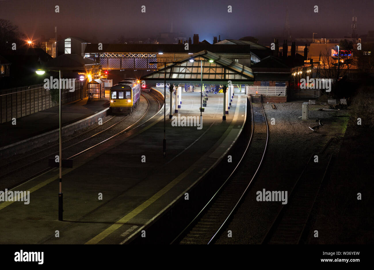 Arriva Nord classe rampa 142 treno dello stimolatore a Bridlington stazione ferroviaria in attesa di partire in una notte buia Foto Stock