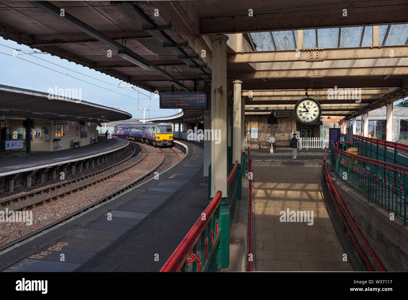 Arriva ferroviaria settentrionale classe 144 treno dello stimolatore a Carnforth stazione ferroviaria con il famoso orologio dal breve incontro film Foto Stock