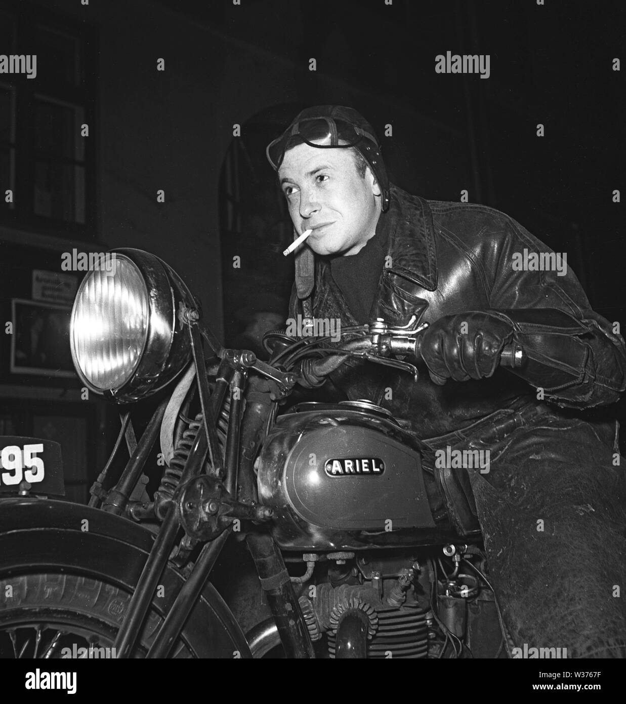 Motociclista nel 1940s. Un giovane uomo che indossa occhiali e un cappuccio in pelle dalla sua moto. Il motociclo è un cittadino britannico di Ariel. La Svezia 1946. Kristoffersson ref T49-3 Foto Stock