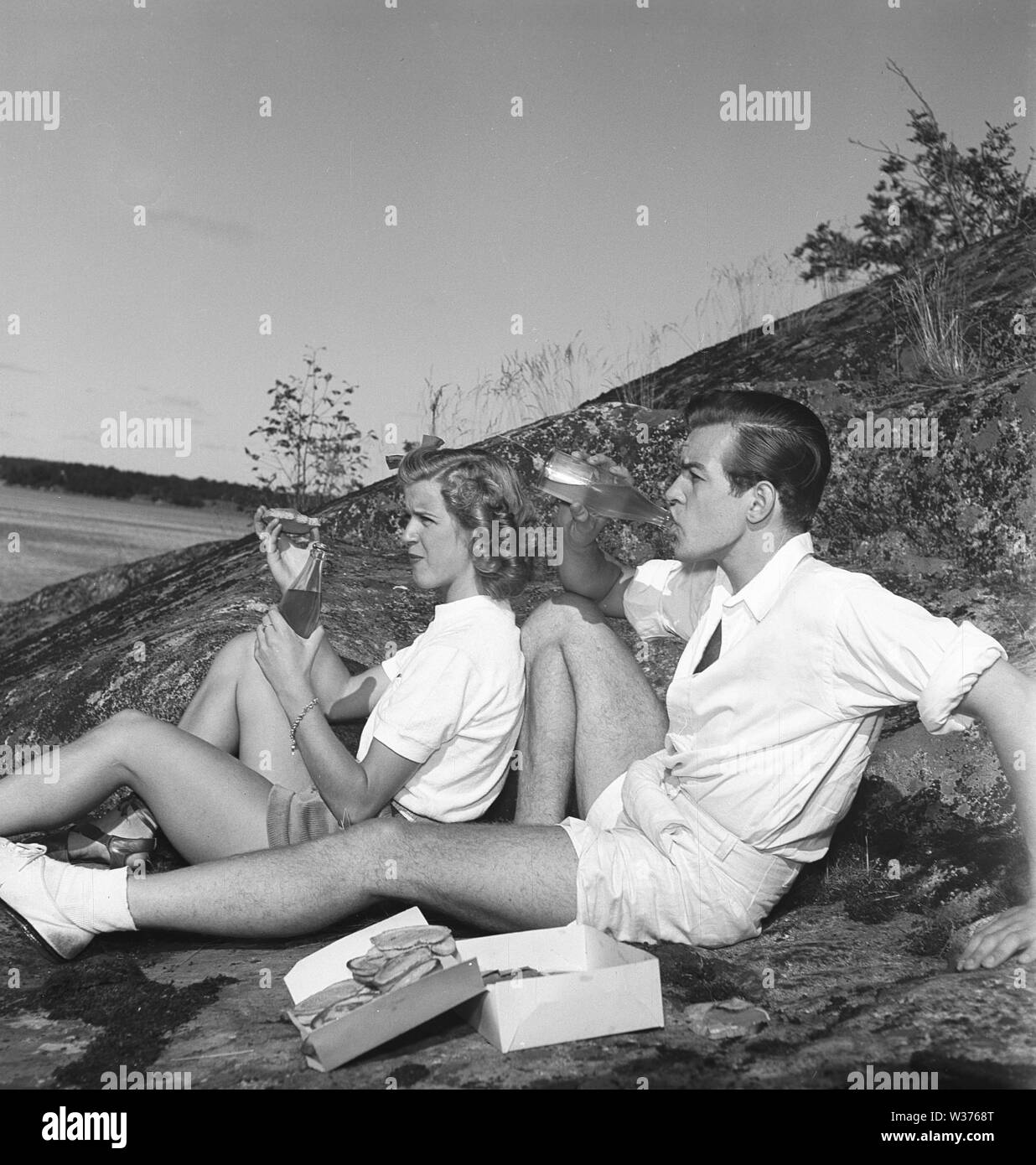 1940s lifestyle. Una giovane coppia sono limonata bere e mangiare panini sul loro picnic. La Svezia. La Svezia 1944 Kristoffersson Ref K82-6. Foto Stock