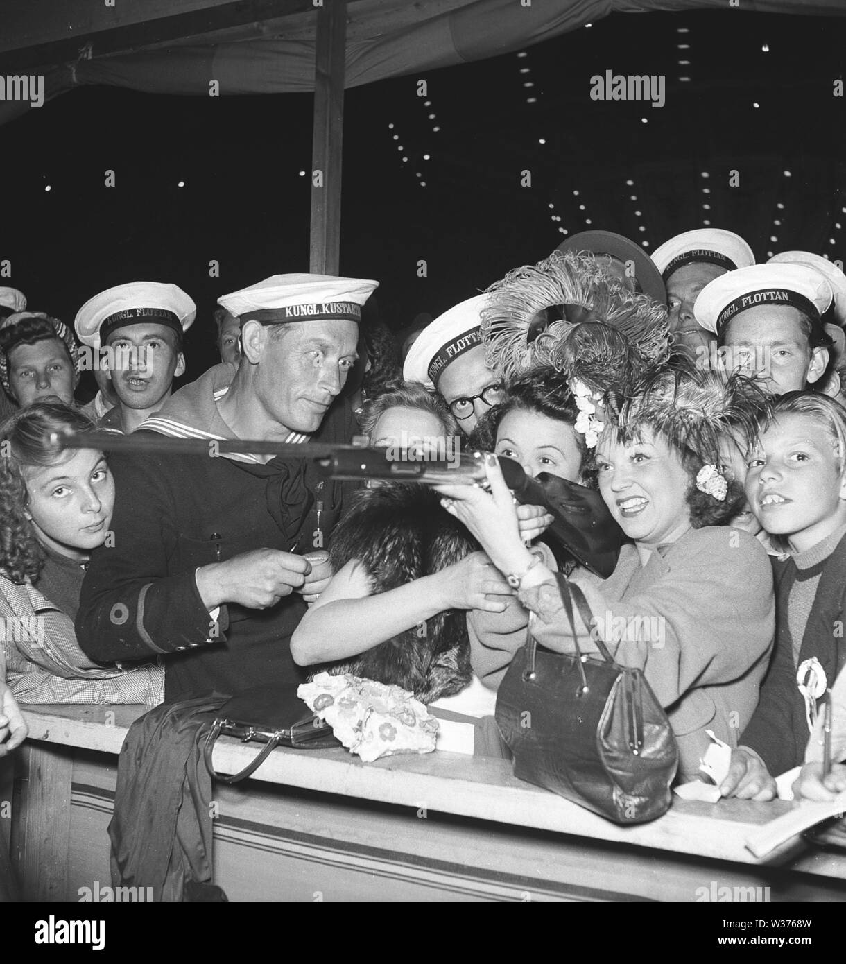 Parco di Divertimenti di 1940s. Un gruppo di marinai ha raccolto intorno a una donna in un gioco di ripresa. La Svezia 1944. Kristoffersson ref G139-4 Foto Stock