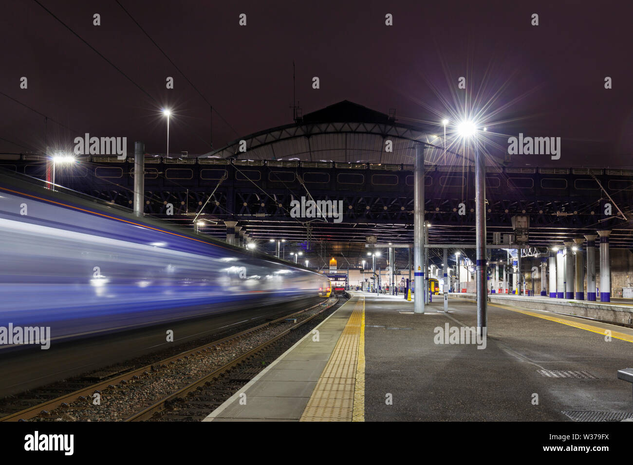 Classe Scotrail 385 elettrico treno in partenza di Glasgow Queen Street con motion blur di notte Foto Stock