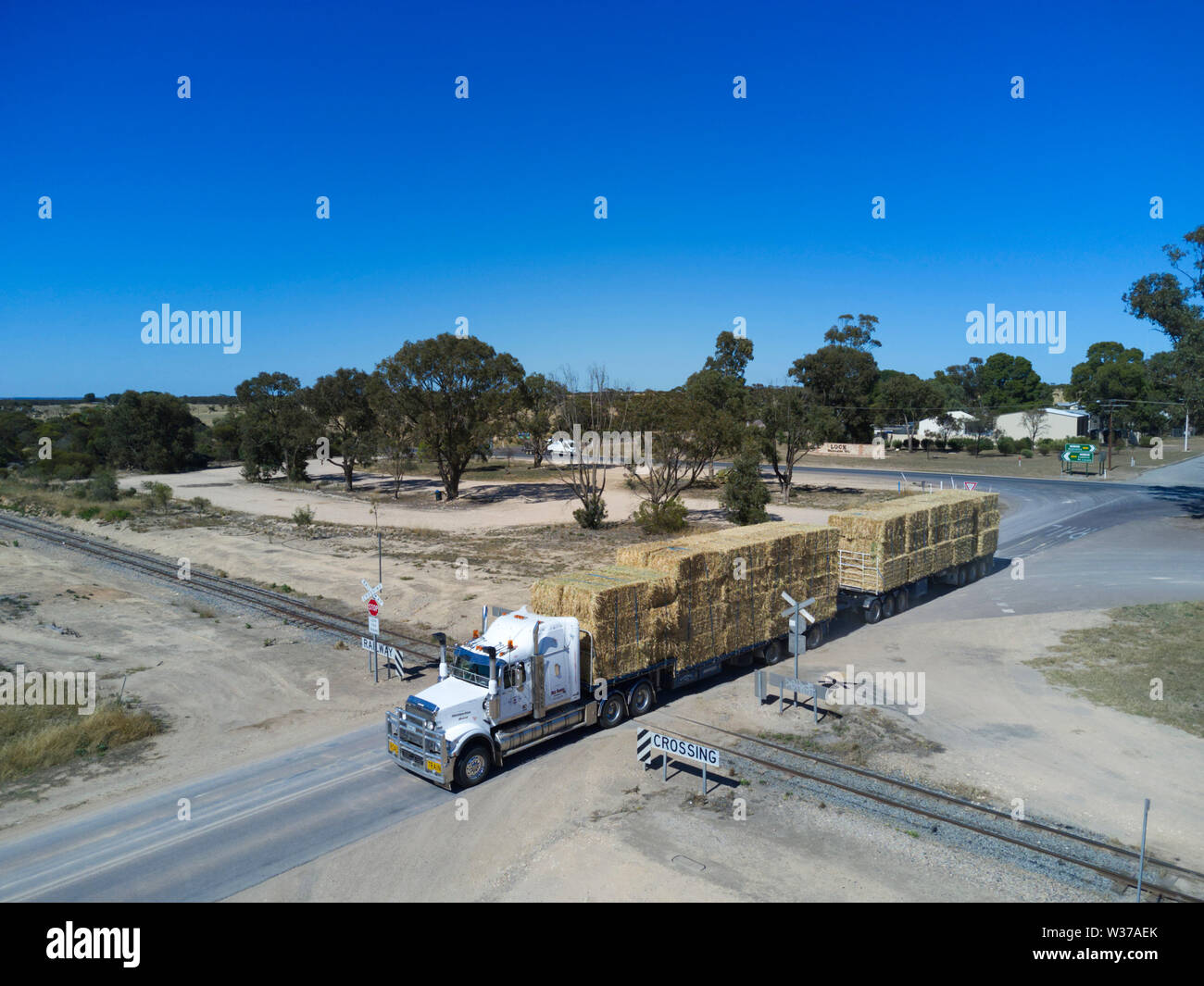 Roadtrain caricato con fieno di attraversare un passaggio a livello ferroviario Bloccare il Sud Australia Foto Stock