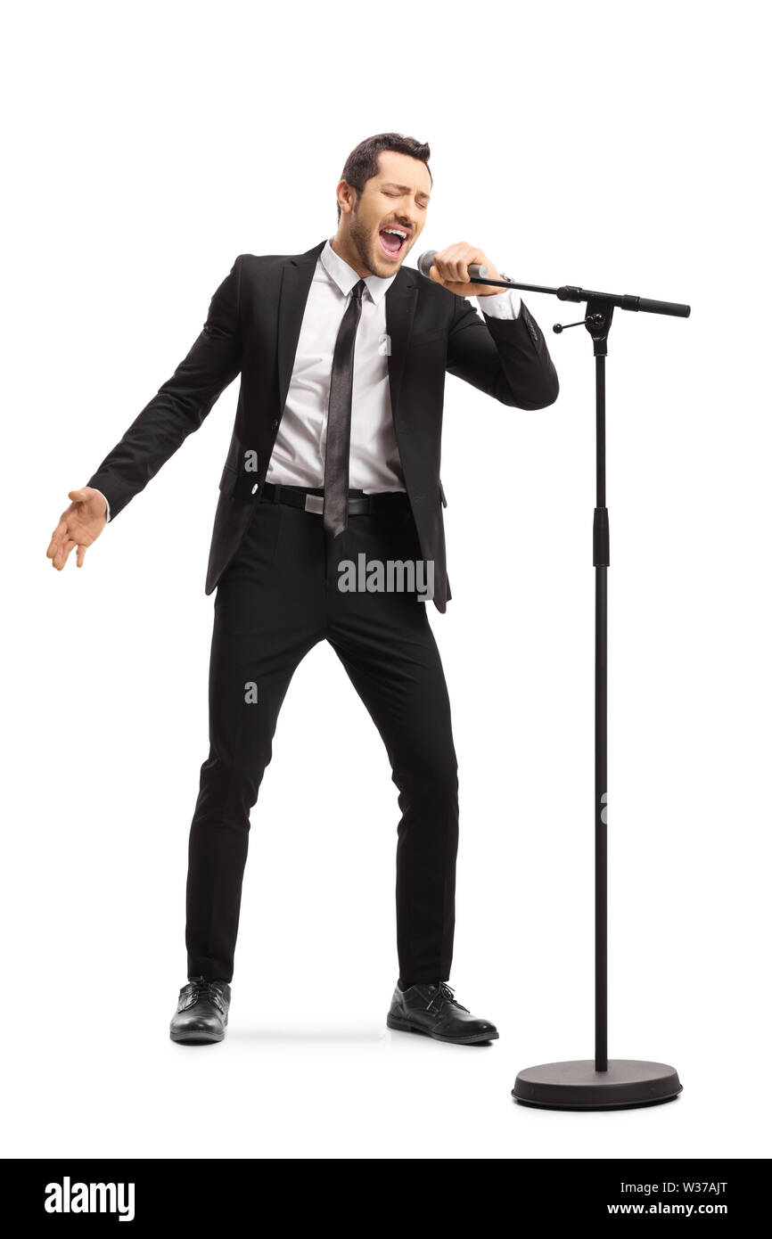 A piena lunghezza Ritratto di un uomo in una tuta cantando su un microfono isolati su sfondo bianco Foto Stock
