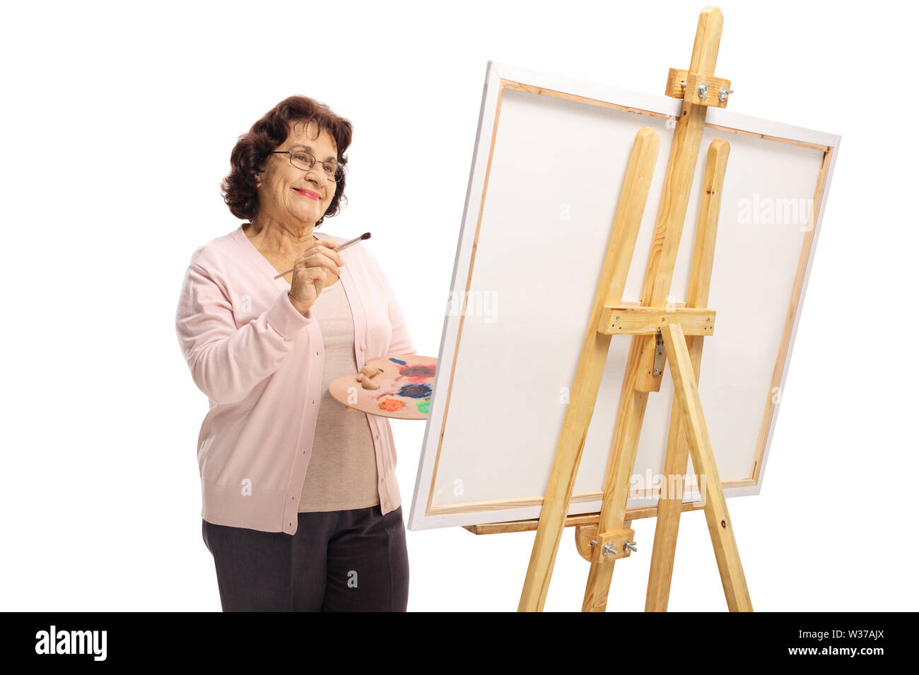 Felice donna anziana con una spazzola e vernici pittura su una tela di canapa isolati su sfondo bianco Foto Stock