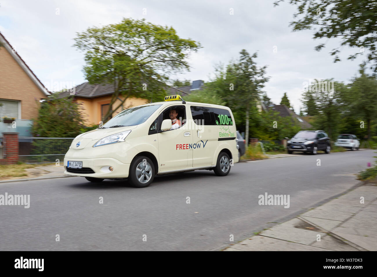 Amburgo, Germania. 12 Luglio, 2019. Kostantin Khmelevskyy, taxi driver, aziona la sua Nissan e-NV 200 Evalia con l'iscrizione: "100% taxi elettrico' su una strada di Lokstedt. Il taxi Khmelevskyy imprenditore è il solo proprietario di una completamente taxi elettrico ad Amburgo. Credito: Georg Wendt/dpa/Alamy Live News Foto Stock