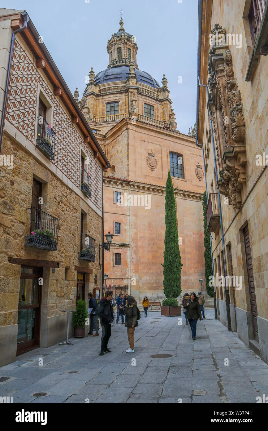 Stretta strada vecchia scena, La Clerecía uno storico barocco chiesa cattolica Salamanca spagna Foto Stock