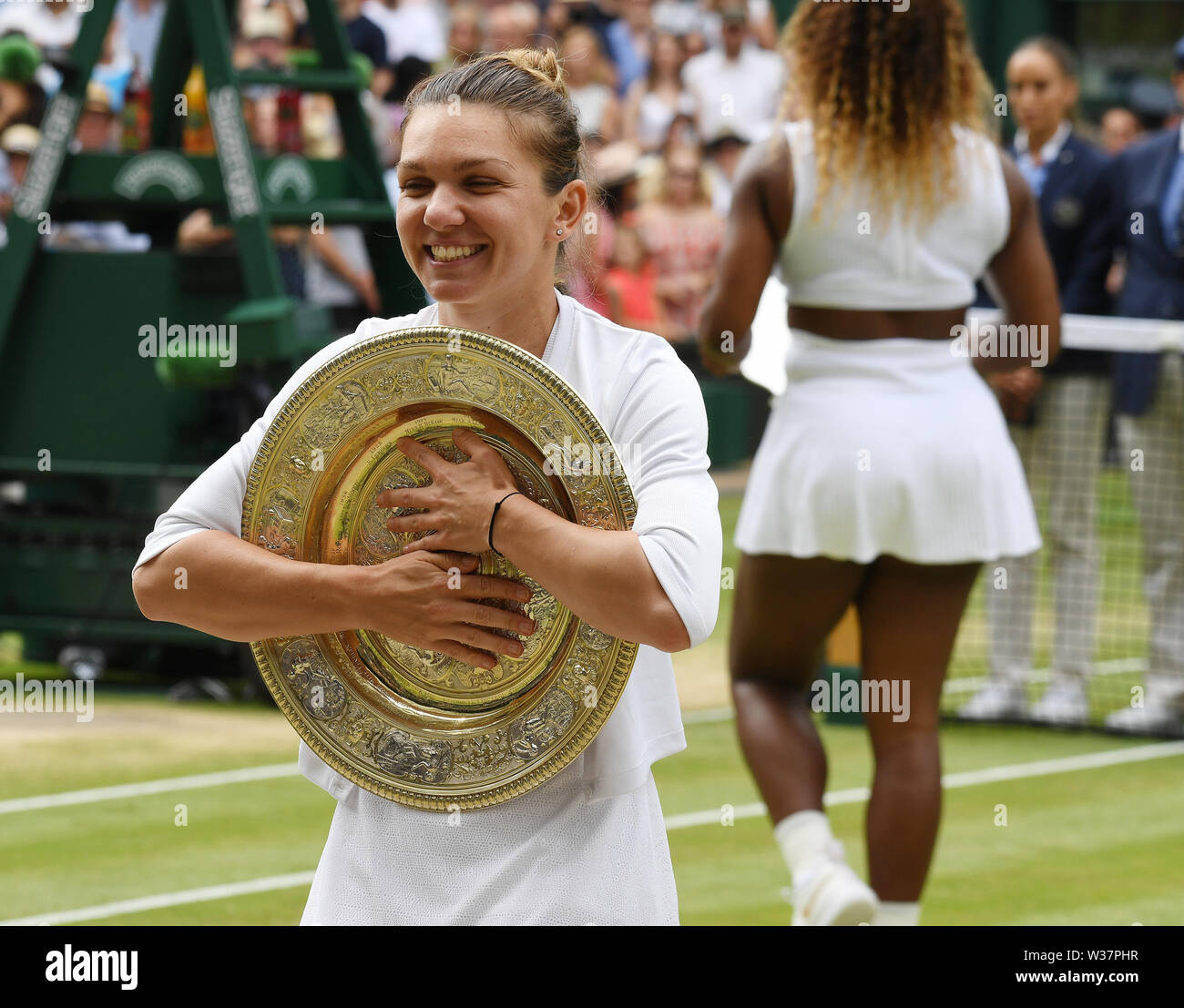 Londra, Regno Unito. 13 Luglio, 2019. I campionati di Wimbledon 2019 13072019 Simona Halep abbracci i vincitori del trofeo Venus rosewater piatto dopo vince Ladies Singles finale, e il suo avversario battuto Serena Williams lascia Centre Court. Credito: Roger Parker/Alamy Live News Foto Stock