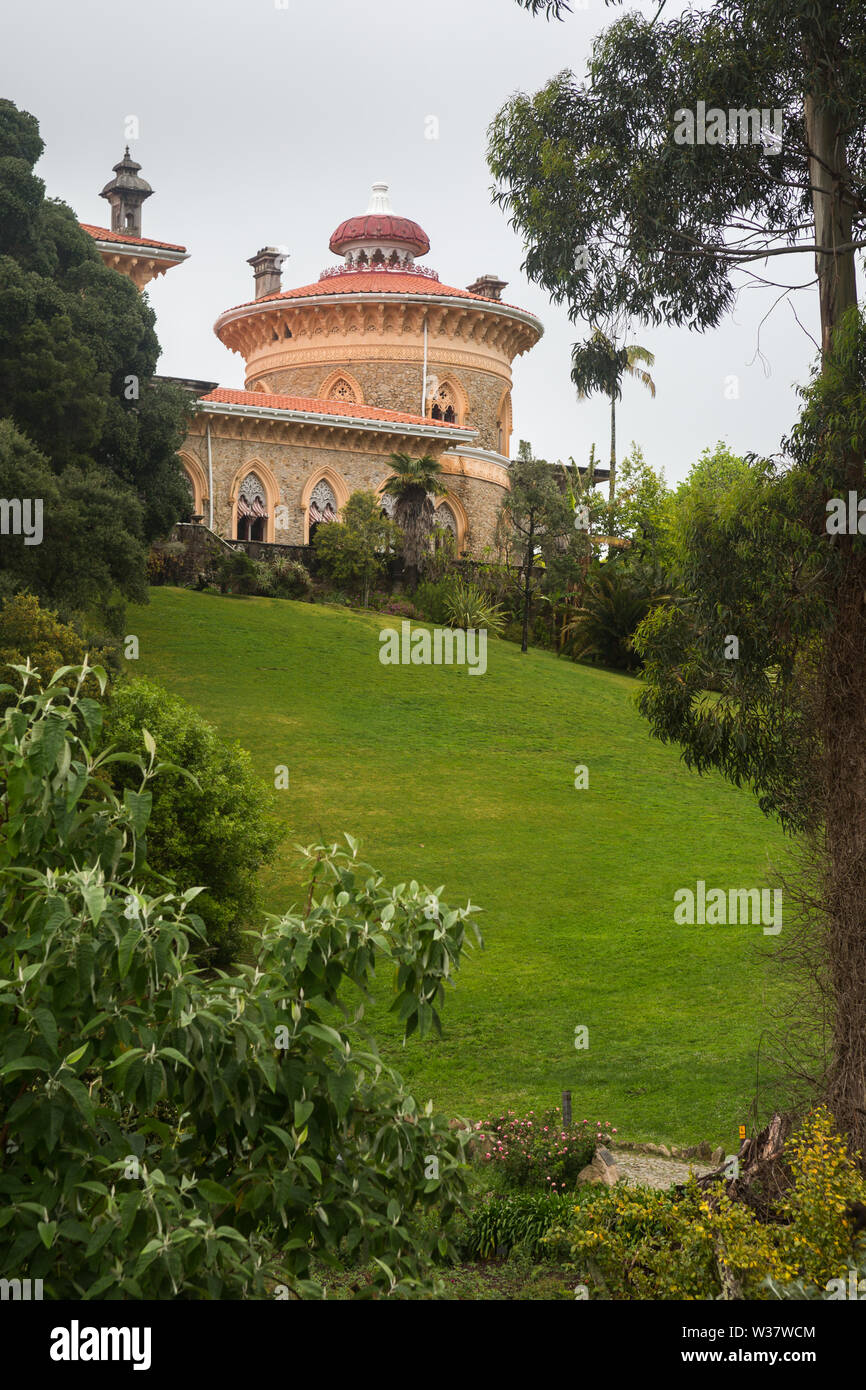 Vista su pendio erboso giardino all'imponente edificio del Patrimonio Mondiale UNESCO Palacio de Monserrate (Monserrate Palace), Sintra, Portogallo Foto Stock