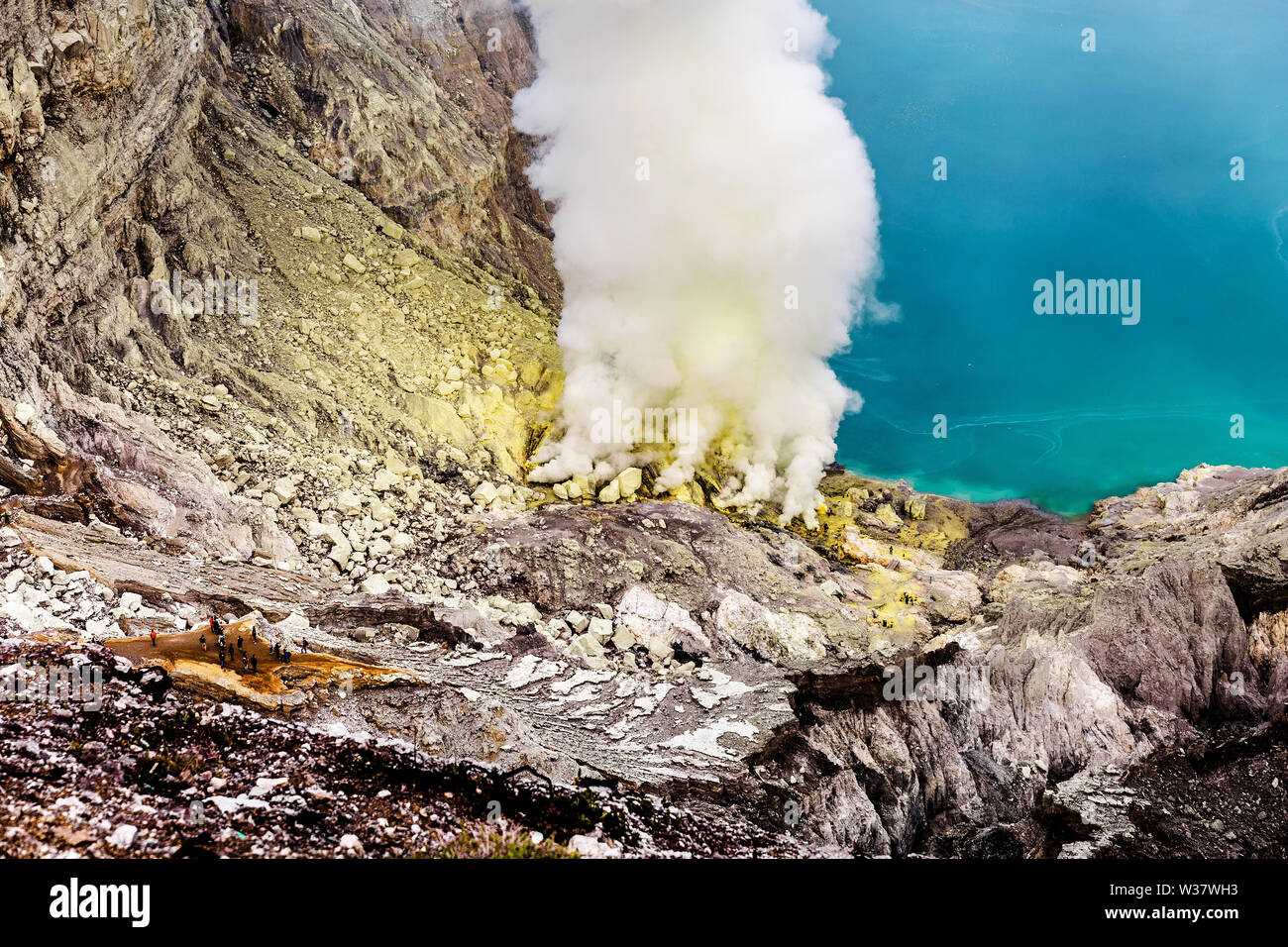 Il cratere di un vulcano con una verde acido solforico lago vulcanico e vulcaniche di fumo. Vista del Vulcano fumatori Kawah Ijen in Indonesia Foto Stock